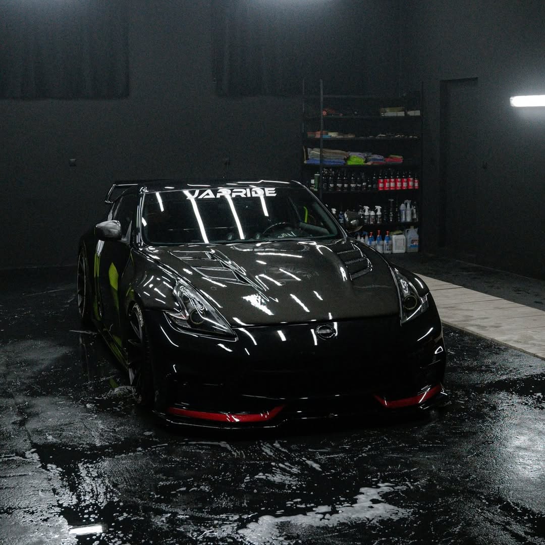 Good Stuff detailing products displayed behind a detailed black sports car