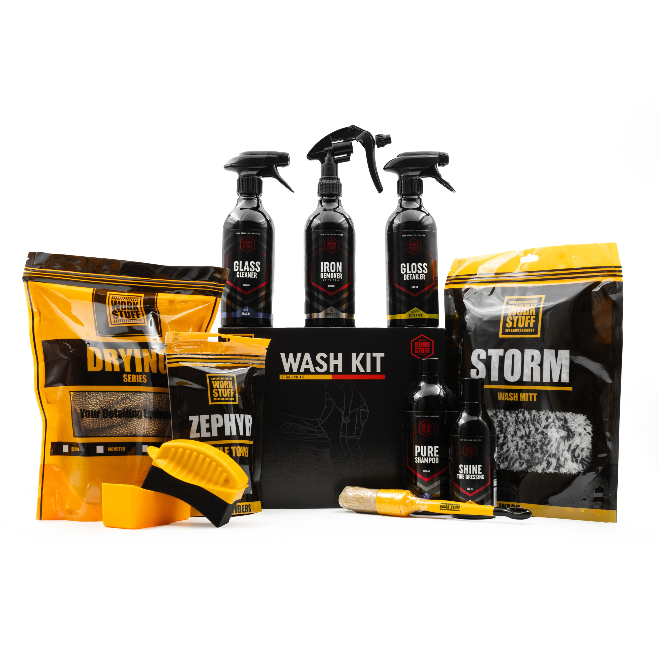 A car wash kit displayed with bottles, mitts, microfiber towels, a sponge, a brush, and cleaning sprays in black and yellow packaging, arranged around a central black box labeled “Wash Kit.”.