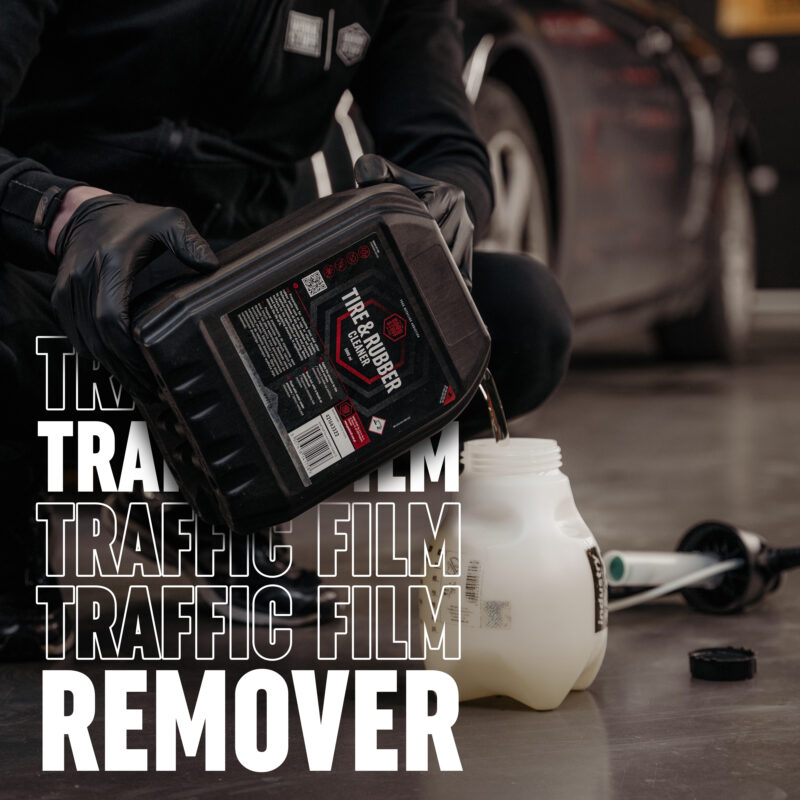 A person in black gloves pours liquid from a black container labeled Tire & Rubber into a white plastic jug, ready to safely remove ice. A car and cleaning equipment are in the background. Bold text reads TRAFFIC FILM REMOVER.