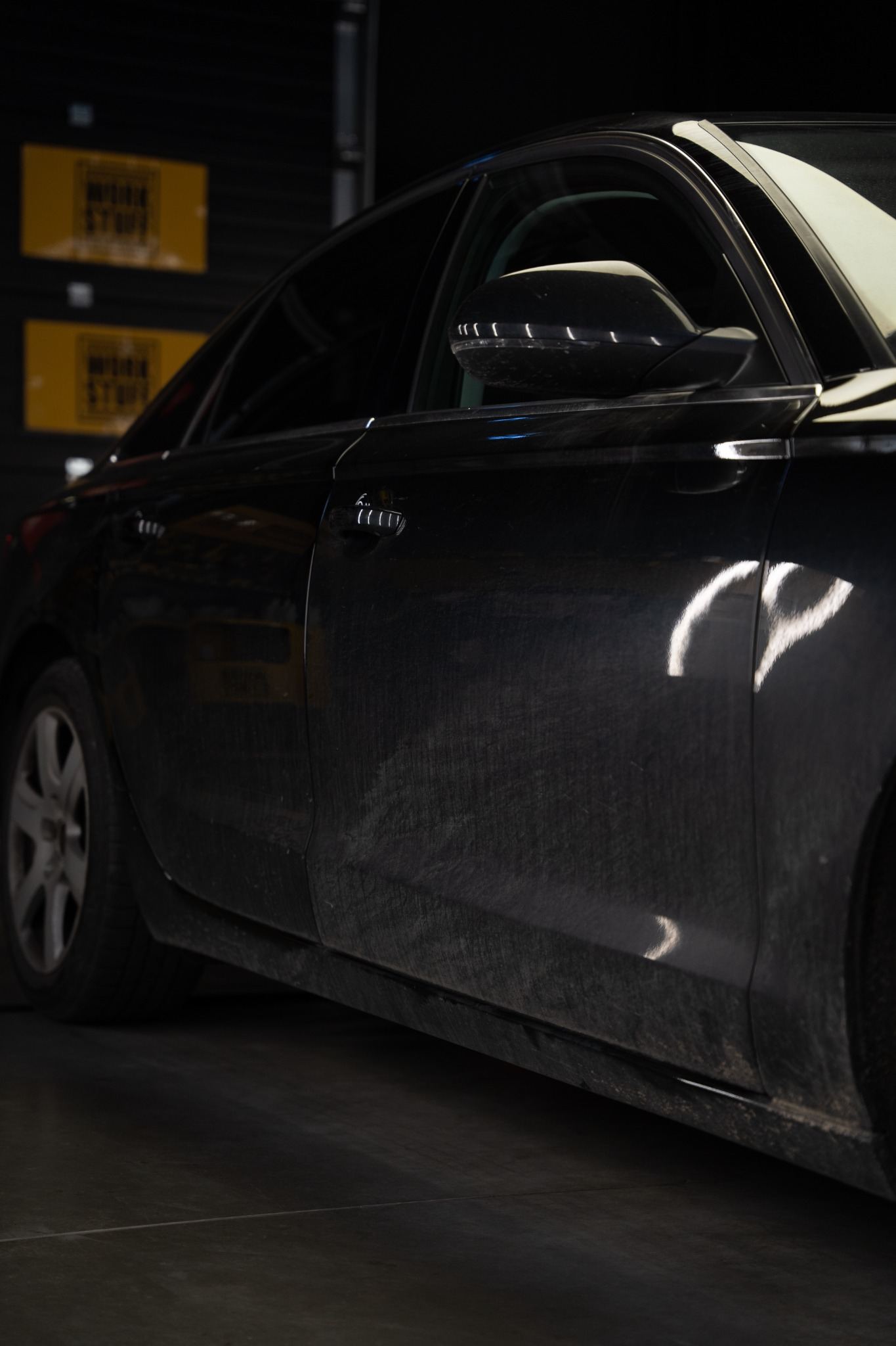 Car with heavy traffic film and road grime on the lower side panels